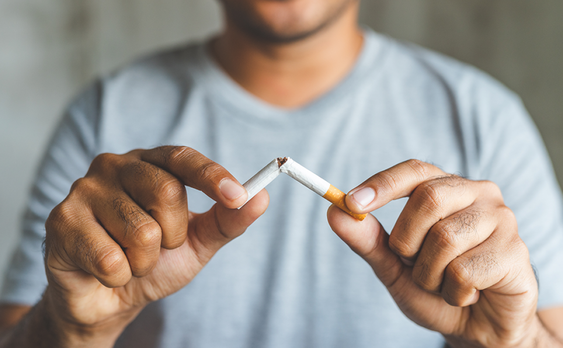 Un homme casse une cigarette en deux