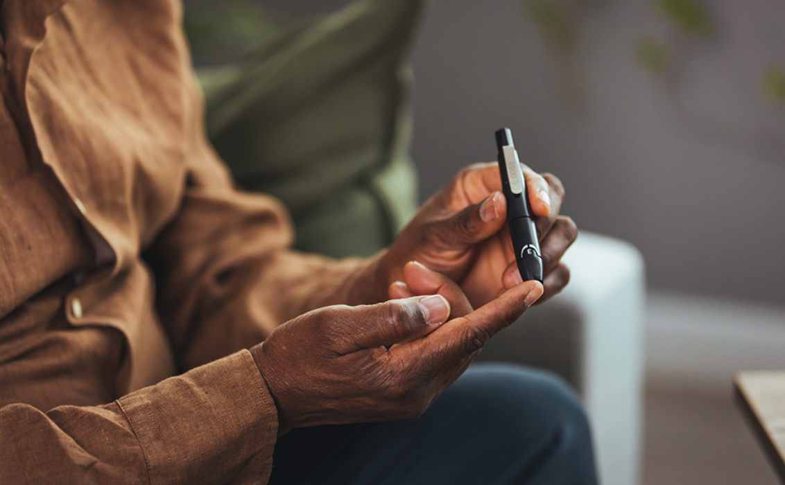 Black man using a blood glucose monitor
