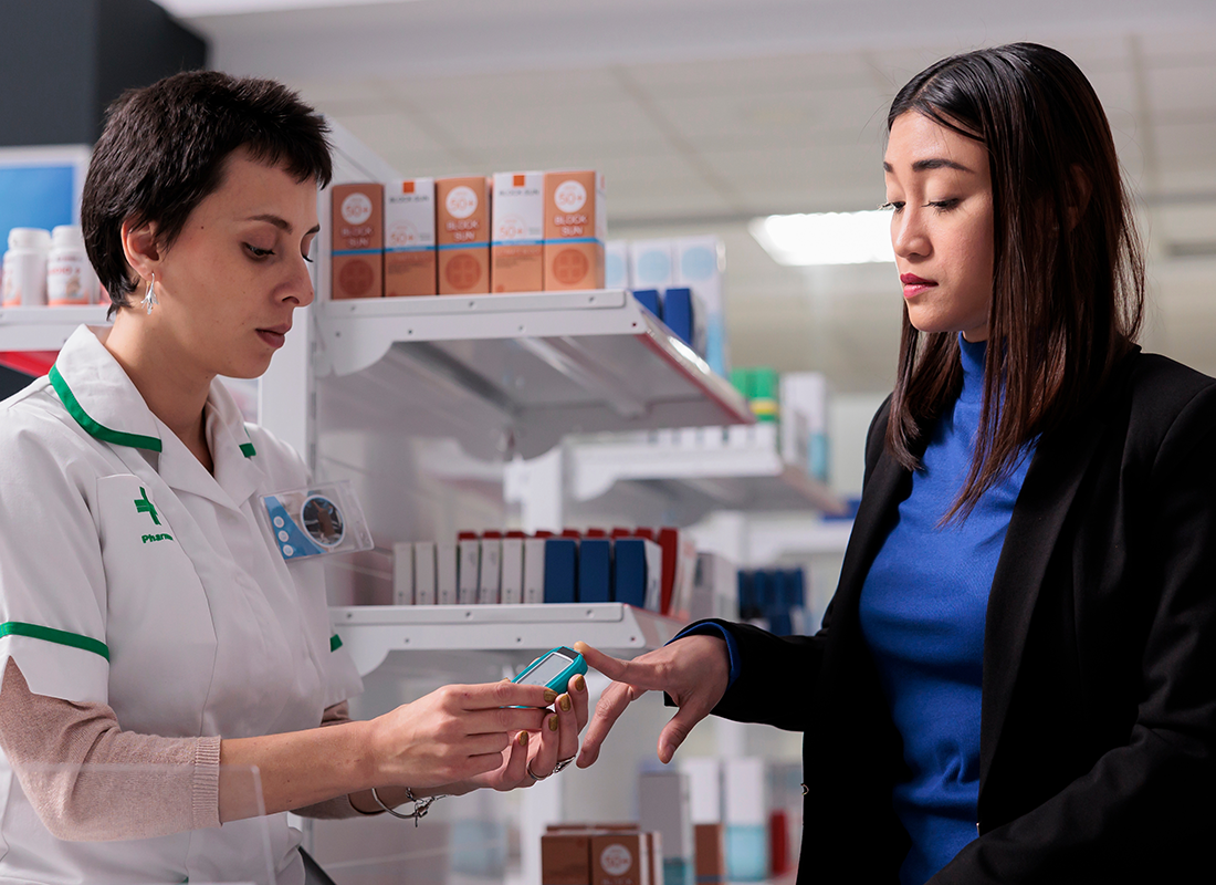 Woman giving blood sample for glucose level testing in drugstore, getting diabetes prevention consultation.