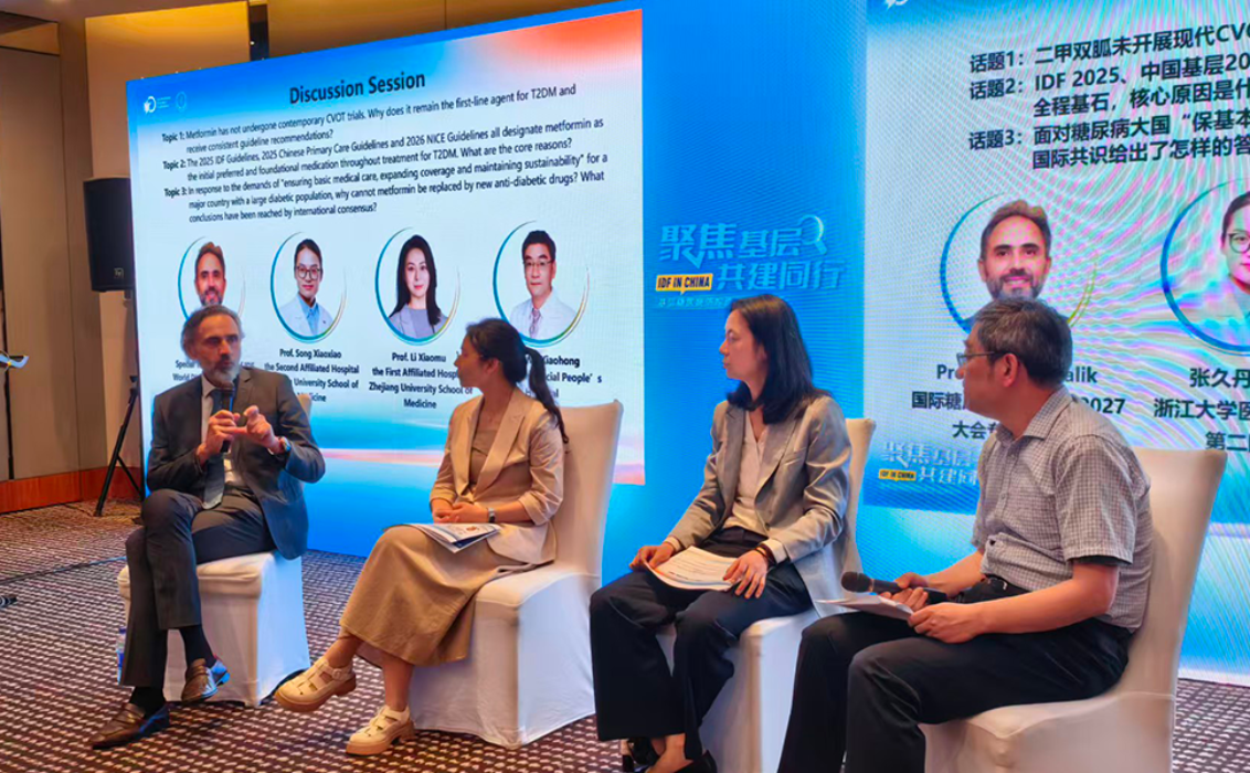Professor Rayaz Malik participates in a panel discussion with Chinese diabetes experts during the IDF Scientific Exchange Tour in China, with a presentation screen displayed in the background.